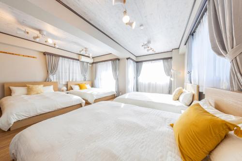two beds in a room with windows at UNITEDCUBE STAY TOKYO Private urban vacation home in Tokyo