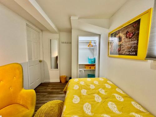 Habitación pequeña con cama y silla amarilla en Private Room on the 1st floor with a Shared Bathroom 10 minutes from SeaTac Airport, en Seattle