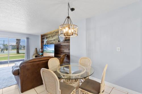 a dining room with a glass table and chairs at Plantation Palms 6103 in Gulf Highlands