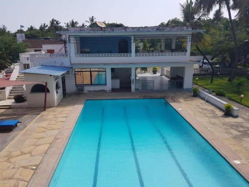 ein Haus mit einem Swimmingpool vor dem Haus in der Unterkunft Modern Apartments Nyali in Mombasa