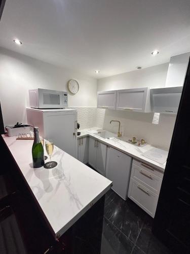 - une cuisine blanche avec une bouteille de vin sur un comptoir dans l'établissement Love Room, La Parenthèse Toulon, à Toulon