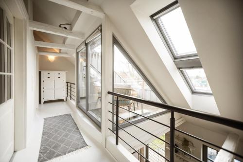 an attic hallway with windows and a staircase at KRABBES große Hafenliebe in Neustadt in Holstein