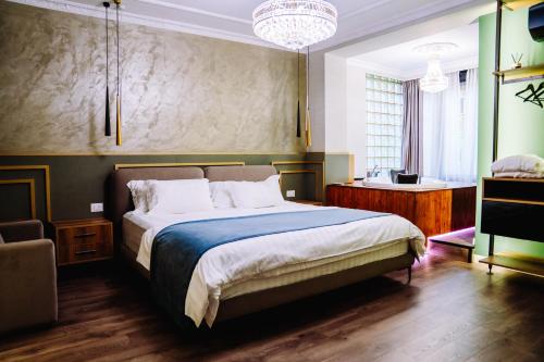 a bedroom with a large bed and a chandelier at NS Luxury Suites in Tirana