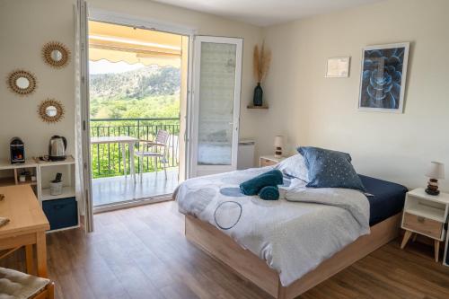 une chambre avec un lit et un balcon dans l'établissement Lumineux studio-Gréoux-les-Bains, à Gréoux-les-Bains