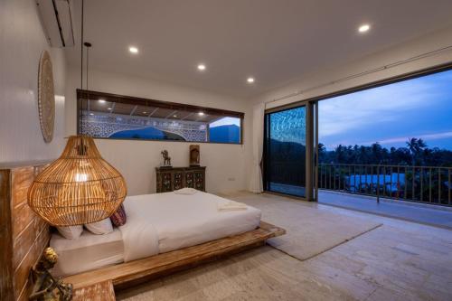 une chambre avec un lit et une grande fenêtre dans l'établissement Villa Ramdas - Maenam, à Ban Mae Nam