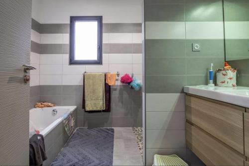 une salle de bain avec une baignoire et un lavabo dans l'établissement Maison Cambier, à Vedène