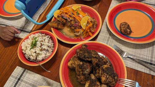 a table with four bowls of food and rice at MoBay Las Palmas in Montego Bay