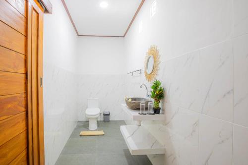 a white bathroom with a sink and a toilet at Ocean View Private Villa in Nusa Lembongan