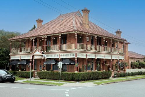 a large wooden building with a balcony on a street at Kings and Queens Paterson in Paterson