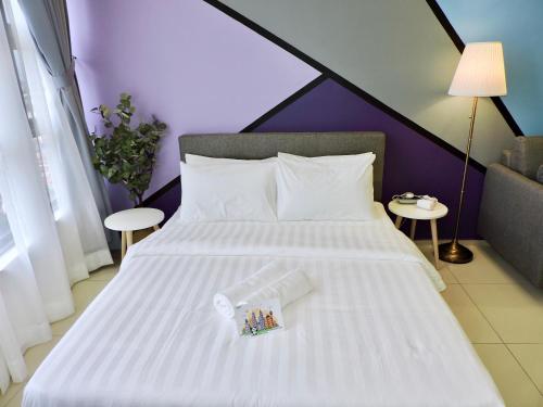 a bedroom with a white bed with two tables at Ekocheras Residence KL Homestay by HomePeace in Kuala Lumpur