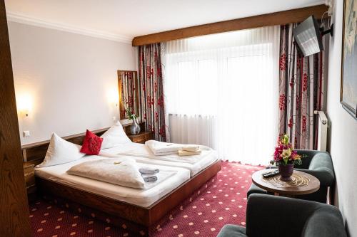 a hotel room with a bed and a window at Hotel Rossmann in Greifenburg