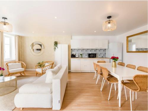 une cuisine et un salon avec une table et des chaises blanches dans l'établissement Merveil Family Suite - Champs Elysees - Roosevelt, à Paris