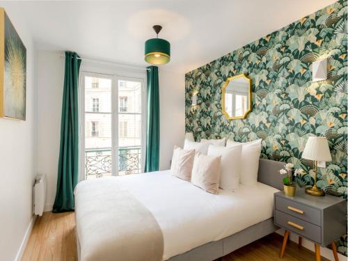 - une chambre avec un grand lit et un mur fleuri dans l'établissement Merveil Family Suite - Champs Elysees - Roosevelt, à Paris