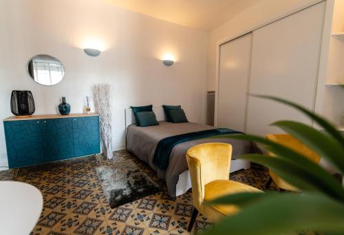 une chambre avec un lit, une table et une chaise dans l'établissement Résidence Touristique Béziers Hyper Centre : A la Ville de Florence, à Béziers