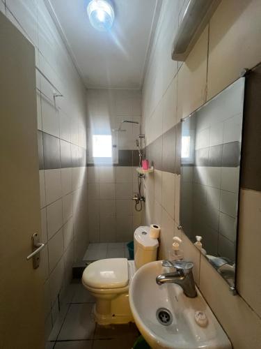a small bathroom with a toilet and a sink at Studio Moderne à Pointe-Noire in Pointe-Noire