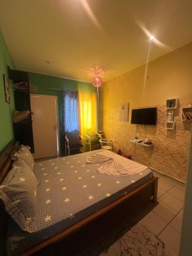 a bedroom with a bed and a television in it at Studio Moderne à Pointe-Noire in Pointe-Noire