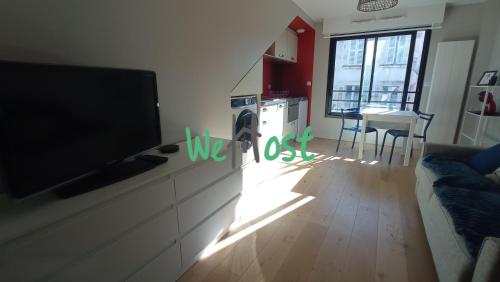 Il comprend un salon avec une télévision à écran plat et une cuisine. dans l'établissement Fonderies Studio Bright Hyper centre, à La Rochelle