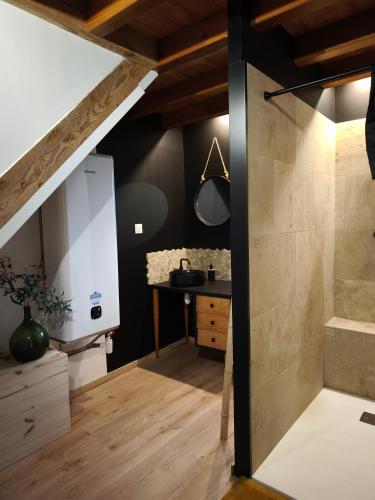 La salle de bains mansardée est pourvue d'une douche et d'un lavabo. dans l'établissement Campagne étoilée, à Bellacaud