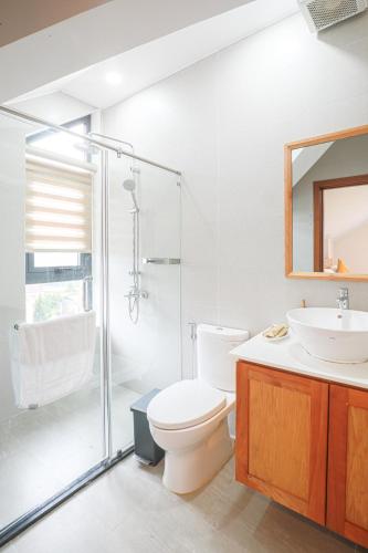 a bathroom with a toilet and a sink and a shower at Cerasoi Boutique Dalat Hotel in Da Lat