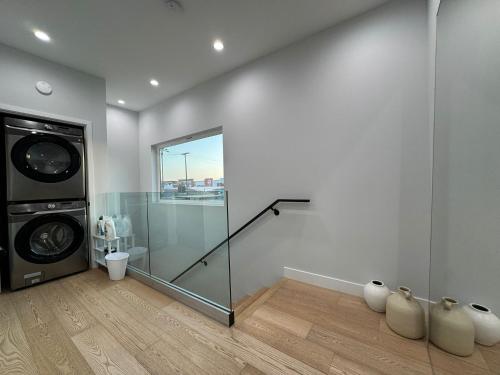 a bathroom with a washing machine and a glass door at Newly constructed 2 bedroom by La Cienega Plaza with parking, modern kitchen, washer dryer and very central to attractions in Los Angeles