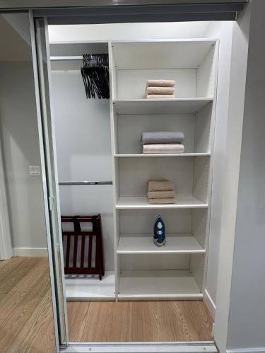 a walk in closet with white shelves and towels at Newly constructed 2 bedroom by La Cienega Plaza with parking, modern kitchen, washer dryer and very central to attractions in Los Angeles