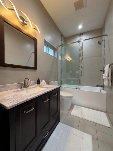a bathroom with a sink and a tub and a shower at Newly constructed 2 bedroom by La Cienega Plaza with parking, modern kitchen, washer dryer and very central to attractions in Los Angeles
