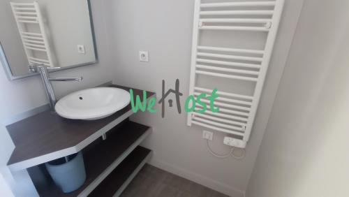 une salle de bain avec un lavabo, des toilettes et un miroir dans l'établissement Fonderies Studio Bright Hyper centre, à La Rochelle