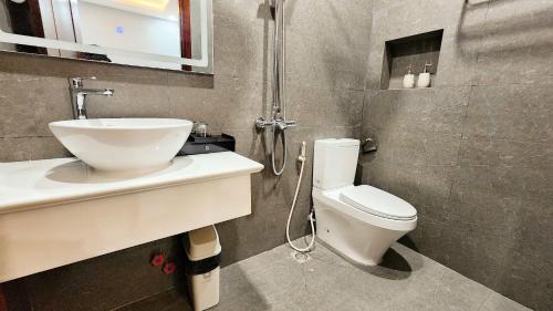 a bathroom with a toilet and a sink and a shower at Trung Đông Hotel in Can Tho