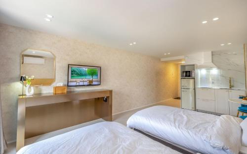 a bedroom with a bed and a kitchen with a sink at THE OCEAN Pension in Sokcho