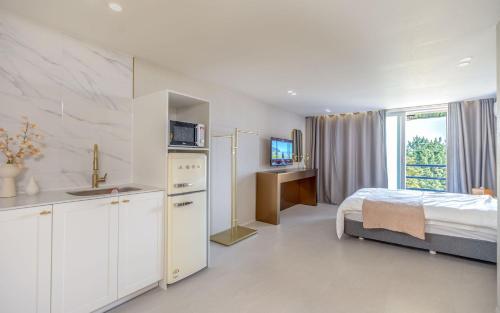 a bedroom with a bed and a kitchen and a sink at THE OCEAN Pension in Sokcho