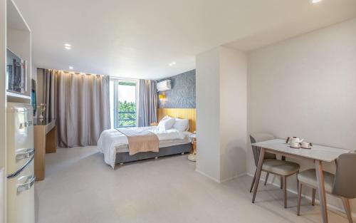 a bedroom with a bed and a desk and a kitchen at THE OCEAN Pension in Sokcho