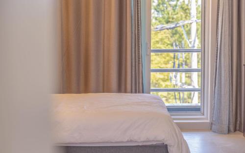 a bed in front of a window in a room at THE OCEAN Pension in Sokcho