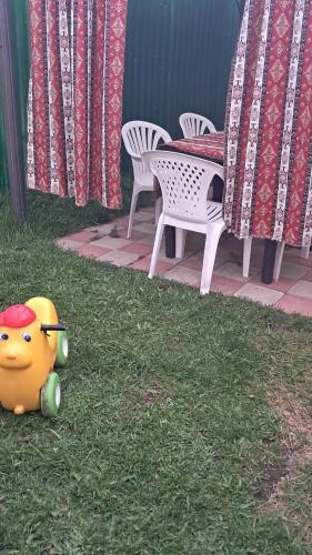 a toy in the grass next to a table and chairs at Manan Guesthouse in Chʼkalovka