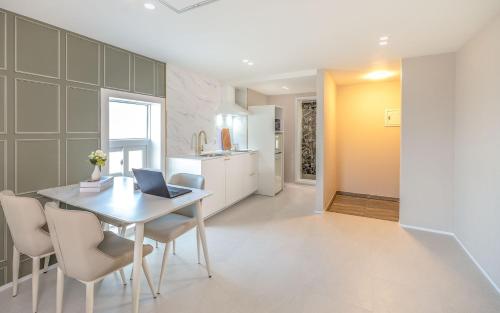 a kitchen and dining room with a table with a laptop at THE OCEAN Pension in Sokcho