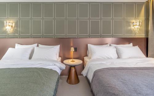 a bedroom with two beds and a lamp on a table at THE OCEAN Pension in Sokcho