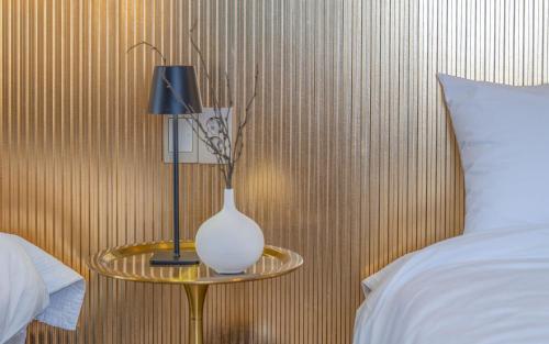 a white vase on a table next to a bed at THE OCEAN Pension in Sokcho