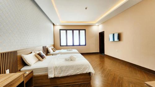 a bedroom with a large bed and a window at Trung Đông Hotel in Can Tho