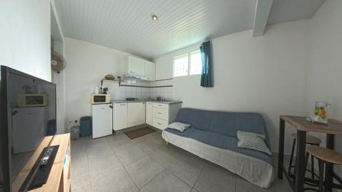 a living room with a couch and a kitchen at AK 101 - L'Océane by Alianskaraib in Rivière-Salée