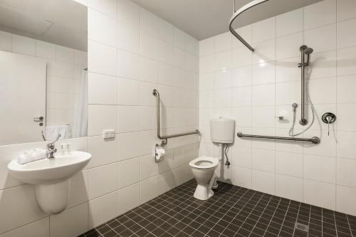 a bathroom with a toilet and a sink at Quest Bundoora in Melbourne