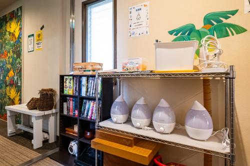 a shelf with four blue and white vases on it at ITO-SPA Guest House YAMATOSO in Ito