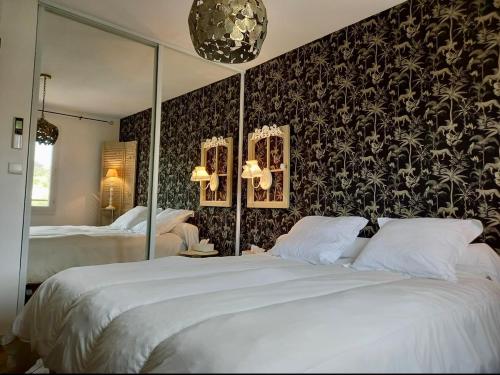 une chambre avec deux lits et un grand miroir dans l'établissement Elegant Duplex, pool and beach, à Roquebrune-sur Argens