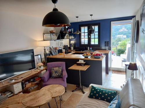 un salon avec une cuisine aux murs bleus dans l'établissement Elegant Duplex, pool and beach, à Roquebrune-sur Argens
