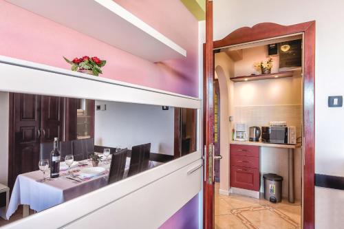 a dining room with a table and a kitchen at Villa Roses Apartments & Wellness in Ičići