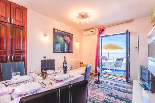 a dining room with a table and a view of the ocean at Villa Roses Apartments & Wellness in Ičići