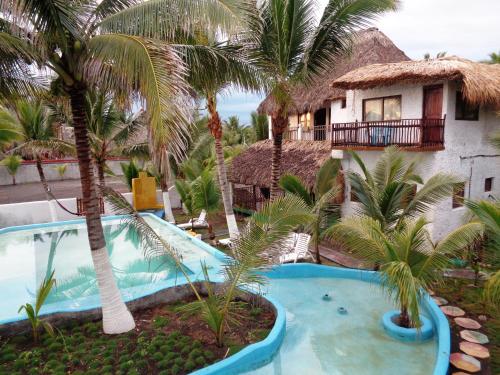 a view of a resort with a pool and palm trees at Marbella Eco Lodge in Monterrico