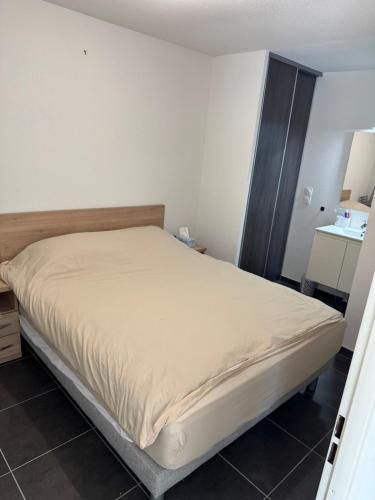 une chambre avec un grand lit dans une pièce dans l'établissement Villa proche plage, à Sérignan