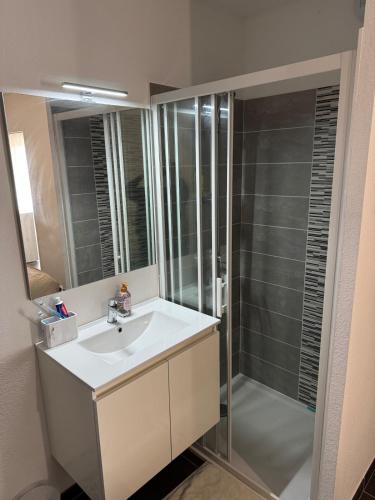 une salle de bain avec un lavabo et une douche dans l'établissement Villa proche plage, à Sérignan