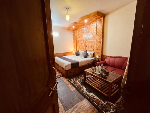 a hotel room with a bed and a couch at The Holly Woods Resort, Manali - Blissful View From Rooms in Manāli