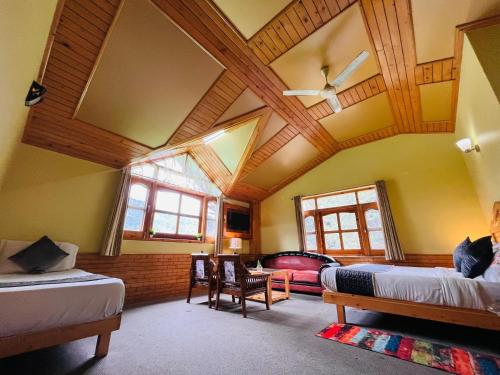 a bedroom with two beds and a wooden ceiling at The Holly Woods Resort, Manali - Blissful View From Rooms in Manāli