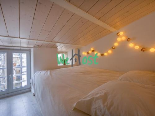 - une chambre dotée d'un lit avec une croix sur le mur dans l'établissement Atypical studio central, à La Rochelle